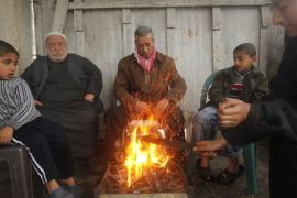 Palestinians men and children gather around a fire outside their home in Gaza City on March 1, 2012, as a cold wave hit the region. AFP PHOTO / MOHAMMED ABED