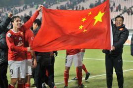 China's Guangzhou Evergrande players wave the Chinese national flag after they defeated South Korea's Jeonbuk Hyundai Motors during their Group H football match of the AFC Champions League in Jeonju, about 200 kms south of Seoul, on March 7, 2012. Guangzhou Evergrande won 5-1. AFP PHOTO/JUNG YEON-JE