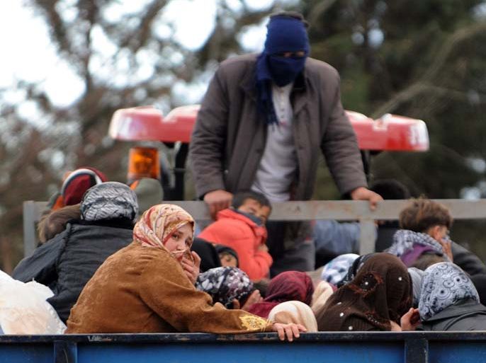 Syrian refugees arrive by truck near the border between Syria and Turkey at Reyhanli in Antakya on March 15, 2012. Some 1,000 Syrian refugees, including a defecting general, crossed into Turkey in 24 hours, braving landmines laid to stop them by Syria's troops, Turkish officials said today.