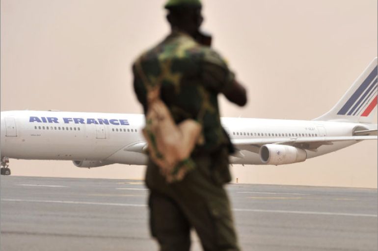 A Malian soldier watches as an Air France aircraft taxis at Bamako airport on March 29, 2012. The bloc of West African states set coup leaders in Mali a three-day ultimatum to restore constitutional order or face diplomatic and economic isolation. AFP PHOTO /ISSOUF SANOGO