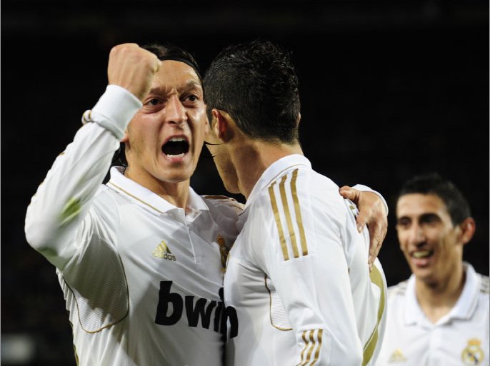 Real Madrid's Portuguese forward Cristiano Ronaldo (R) celebrates with Real Madrid's German midfielder Mesut Ozil (L) after scoring his team second goal during the Spanish League "El clasico" football match Barcelona vs Real Madrid at the Camp Nou stadium in Barcelona on April 21, 2012. AFP PHOTO/JAVIER SORIANO