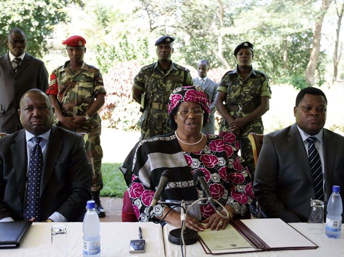 Malawi’s then-Vice President Joyce Banda (C) flanked by Malawi Defense Force Commander General Henry Odilo (R) and Inspector General Peter Mukhito announces on April 7, 2012 the death of President Bingu wa Mutharika in Lilongwe. President Mutharika who suffered a cardiac arrest in Lilongwe on April 5, 2012