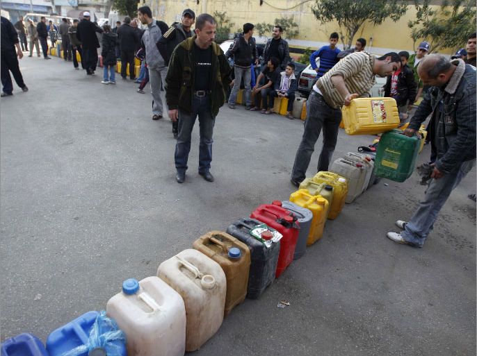 Palestinians wait in a queue to fill containers with fuel at a petrol station in Gaza City on April 2, 2012. The International Committee of the Red Cross (ICRC) began transferring emergency supplies of fuel to the Gaza Strip where an electricity crisis has hit medical services hard. AFP PHOTO/MOHAMMED ABED