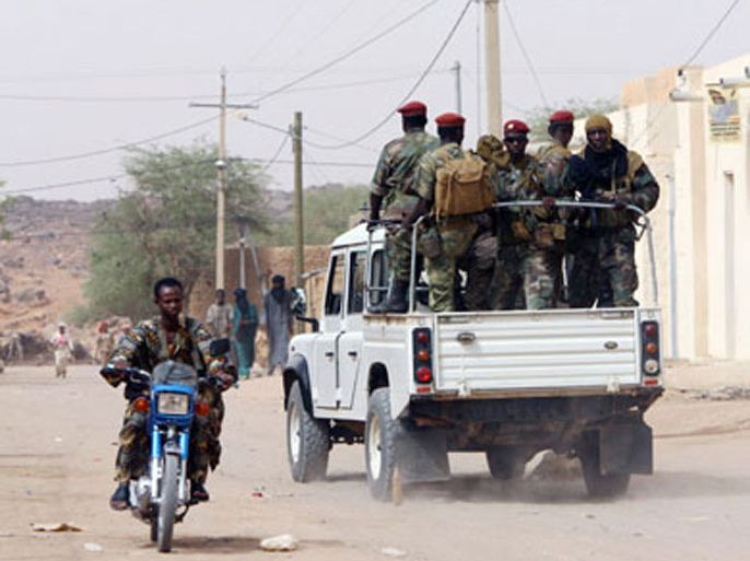 A file photograph dated 18 October 2011 shows Tuareg rebel fighters moving through northern Mali on a pick-up truck with a mounted heavy machine gun