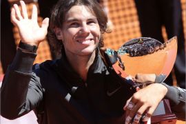 Spain's Rafael Nadal acknowledges the audience as he celebrates with his trophy after winning the Monte Carlo ATP Masters Series Tennis Tournament final against Serbia's Novak Djokovic on April 22, 2012 in Monaco. Nadal won 6-3 6-1. AFP PHOTO SEBASTIEN NOGIER