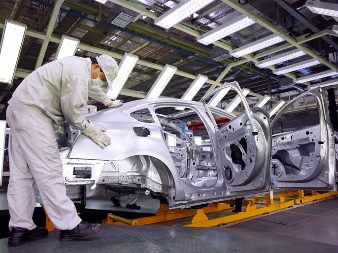 An employee works on an assembly line at a car factory in Shanghai, China on 24 December 2009