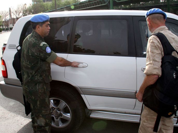 Members of a UN monitors team, tasked with monitoring the UN-backed ceasefire in Syria, arrive at a hotel in Damascus on April 18, 2012. UN observers have acknowledged that they face a tough task to firm up a ceasefire in Syria, as seven civilians were killed Tuesday in the latest violence on the sixth day of a tenuous truce. AFP PHOTO / LOUAI BESHARA