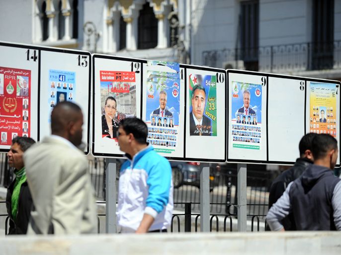 People walk past candidate's posters for the May 10 legislative elections in Algiers on April 21, 2012. The campaign began this week for polls President Abdelaziz Bouteflika's regime bills as part of an unprecedented reform process and come amid deep political upheaval in most of Algeria's neighbouring states. AFP