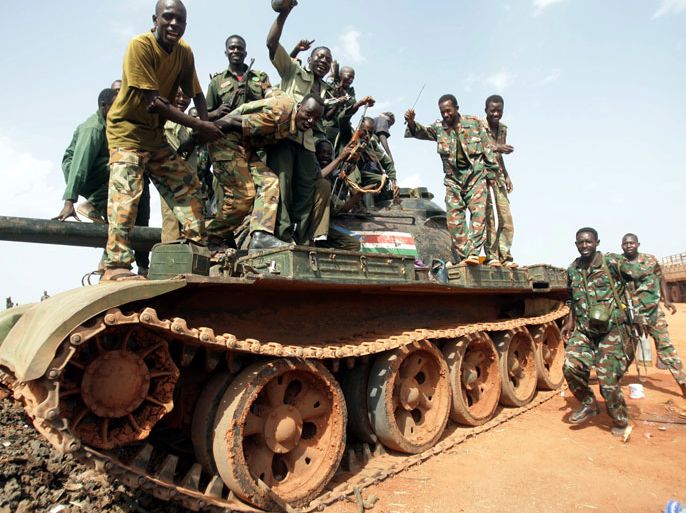 epa03193947 Sudanese soldiers pose on a tank during their celebration in Heglig, Sudan, 23 April 2012. The European Union on 23 April urged Sudan and South Sudan to stop their escalating conflict, as France warned that the bloc might resort to sanctions to pressure the two sides into ceasing hostilities. They urged South Sudan to make good on promises to withdraw from the disputed Heglig oil fields and on Sudan to stop air raids on South Sudanese territory. EPA/STR