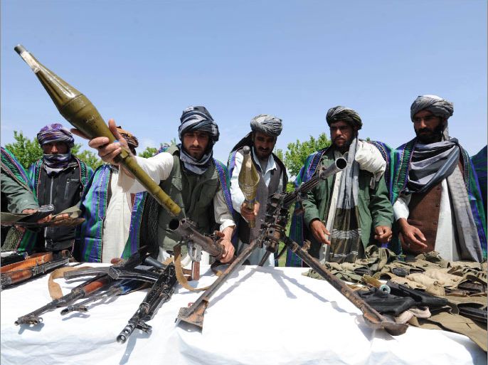 Former Taliban fighters display their weapons as they join Afghan government forces during a ceremony in Herat province on April 26, 2012. Ten fighters left the Taliban to join government forces in western Afghanistan. The Taliban were ousted from power by a US-led invasion in the wake of the 9/11 attacks. AFP PHOTO / Aref KARIMI