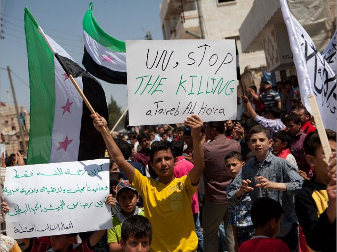 Syrian protesters shout slogans as they hold pre-Baath national flags, which is adapted by oppositions, during an anti-regime demonstration in the town of Atareb, 30km west of Aleppo, on April 27, 2012. Tens of thousands protested across Syria as a deadly suicide bombing rocked the capital, killing 11 people and fuelling growing scepticism over the prospects of a UN-backed peace plan. AFP PHOTO/DLO