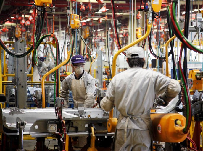 Workers work on an assembly line at a car factory in Shanghai, China on 24 December 2009