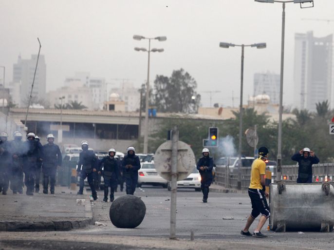 Riot police approach from the main highway as a protester stands in front of them during clashes after a rally held in support of opposition members currently serving life in prison, in the village of Bilad al-Qadeem, west of Manama, April 1, 2012. REUTERS
