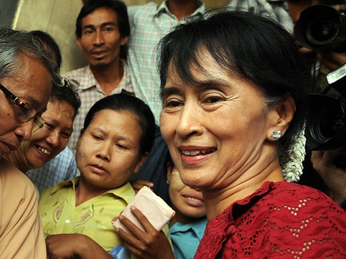 Myanmar opposition leader Aung San Suu Kyi is surrounded by supporters and journalists as she visits a polling station in the constituency where she stands as a candidate in Kawhmu on April 1, 2012. Voting began in Myanmar elections seen as a test of the government's budding reforms, with opposition leader Aung San Suu Kyi standing for a seat in parliament for the first time. AFP