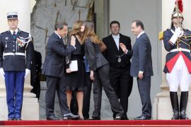 France's outgoing president Nicolas Sarkozy (L) salutes his successor Francois Hollande (R) as French First Lady Carla Bruni (2ndR) kisses Valerie Trierweiler (2ndL), companion of the French President-elect as the former presidential couple is about to leave the Elysee presidential Palace after the formal investiture ceremony