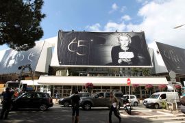 People walk, on May 14, 2012, past a giant official poster of the 65th Cannes' film festival featuring late Marilyn Monroe on the facade of the Festivals' palace in Cannes, southeastern France. David Cronenberg, Ken Loach and Michael Haneke are among the 22 international film-makers vying for the Palme d'Or award at the 65th anniversary edition of the leading world cinema showcase which runs from May 16 to 27