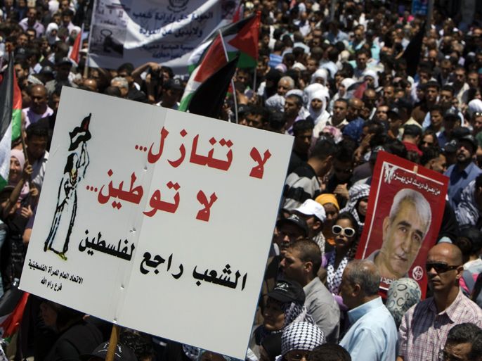 Palestinian demonstrators wave Palestinian flags and a banner reading in Arabic: "No giving up, no nationalization, the people will return to Palestine" during a rally in the West Bank city of Ramallah on May 15, 2012, marking Nakba day, which commemorates the exodus of hundreds of thousands of their kin after the establishment of Israel state in 1948. AFP