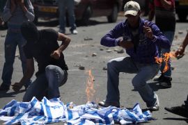 Palestinian youths burn Israeli flags during 'Nakba day' protests in the east Jerusalem Arab neighborhood of Issawiya on 15 May 2012. Palestinians mark Nakba day, which commemorates the exodus of their kin after the establishment of Israel state in 1948. EPA/ABIR SULTAN