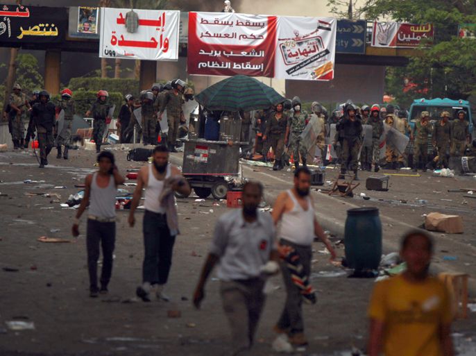 Egyptian protesters walk away after army troops fired tear gas to disperse an anti-military demonstration outside the defense ministry in Cairo's Abbassiya district on May 4, 2012. Heavy gunfire could be heard as clashes between troops and anti-military protesters spread around the ministry building and street battles raged in side roads. AFP