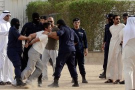 Kuwaiti policemen detain demonstrators during a protest by stateless people, locally known as bidoons, to demand citizenship and other basic rights in Jahra, 50 kms (31 miles) northwest of Kuwait City, on May 1, 2012. AFP PHOTO/YASSER AL-ZAYYAT