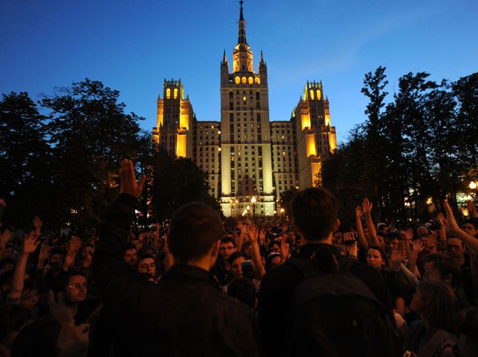 Opposition activists rally during an anti-Putin 'occupy' sit-in protest at their new camp under a famous Stalin-era skyscraper in Moscow, late on May 17, 2012. Russians unhappy with Vladimir Putin's presidential return after a four-year stint as prime minister have been increasingly turning to creative forms of protest that slip through legal loopholes and do not require formal city sanction. AFP