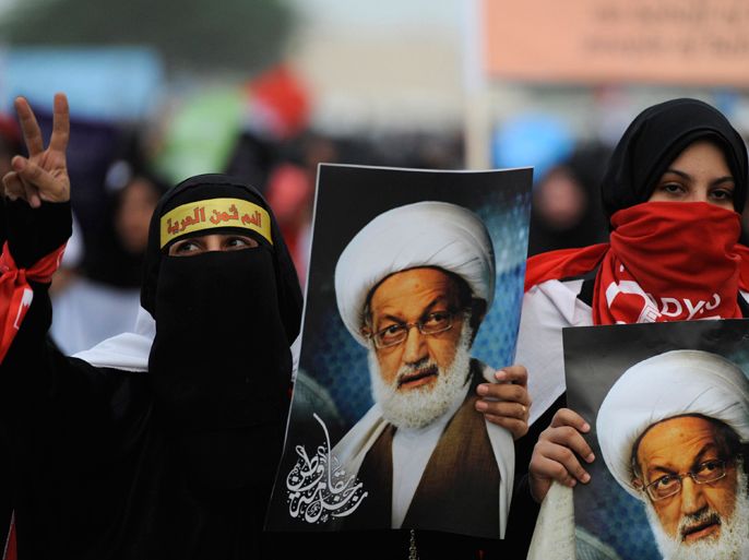 Anti-government protesters hold posters of Shi'ite scholar Isa Qassim as they participate in a rally held to condemn the Bahrain Saudi union on the Budaiya highway, west of Manama, May 18, 2012. Tens of thousands of mainly Shi'ite protesters rallied in Bahrain on Friday against proposals for closer ties with other Gulf Arab countries, a plan pushed by Saudi Arabia to contain dissent in Bahrain and counter Iran's regional influence. REUTERS