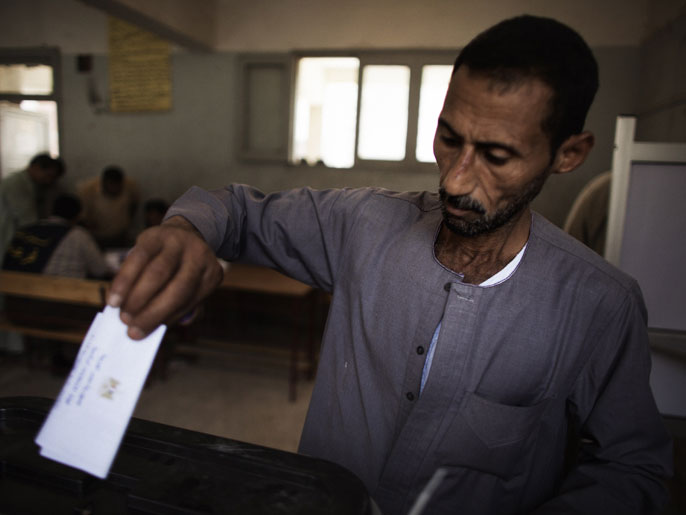 Cairo, -, EGYPT : An Egyptian man casts his ballot at a polling station in the Manshiyet Nasser district in Cairo on May 23, 2012, during historic presidential elections, the first since a popular uprising toppled Hosni Mubarak.
