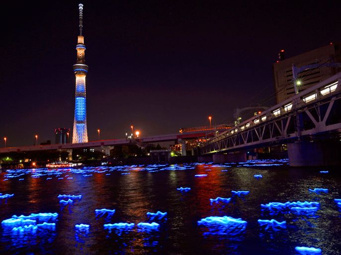 A slow shutter speed image shows LED lights on the Sumida River near the Tokyo Sky Tree in downtown Tokyo, Japan, 06 May 2012. Tokyo Hotaru Festival runs from 05 to 06 May 2012. About 100,000 LED lights are released into the Sumida River late on 06 May. EPA/TOMOYUKI KAYA