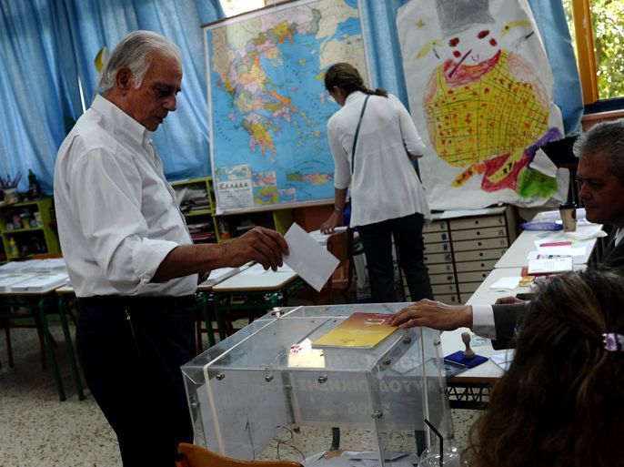 GREECE : A man casts his vote during Greece's general elections in Athens on May 6, 2012. Greeks voted Sunday in a tough-to-predict general election that threatened to turn the crisis-hit country's old political system on its head and bring eurozone turmoil back with a vengeance. AFP