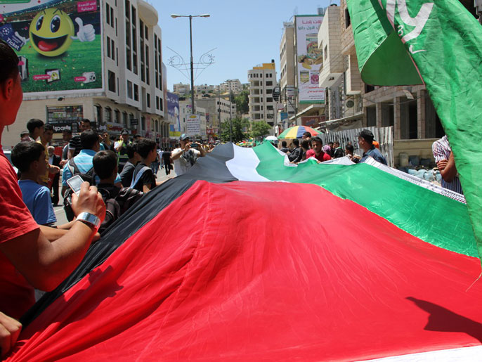 متظاهرون يرفعون العلم الفلسطينيفي تجسيد للوحدة الوطنية (الجزيرة نت)