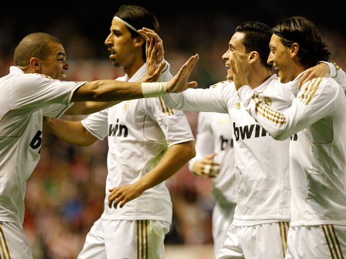 Real Madrid's German midfielder Mesut Ozil (R) celebrates with teammates after scoring during the Spanish league football match Athletic Bilbao against Real Madrid at the San Mames stadium in Bilbao on May 2, 2012.AFP