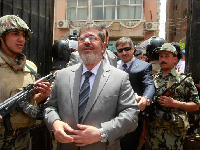 Islamic presidential candidate Mohamed Mursi arrives to a polling station to cast his vote in Al-Sharqya, 60 km (37 miles) northeast of Cairo, May 23, 2012. Egyptians queued patiently to vote on Wednesday, eager to pick their leader for the first time in a national history dating to the pharaohs, with Islamists and secular-minded rivals who served under deposed President Hosni Mubarak heading the field.   REUTERS/Asmaa Waguih (EGYPT - Tags: POLITICS ELECTIONS)