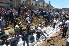 A handout picture released by the Syrian opposition's Shaam News Network shows people watching the mass burial on May 26, 2012 of more than 100 victims killed in the central Syrian city of Houla in a massacre condemned by world leaders and described on May 28 by visiting UN-Arab League envoy Kofi Annan as "an appalling moment with profound consequences." While Syria's opposition renewed its call to the international community to help Syrians defend themselves, Damascus' UN envoy Bashar Jaafari said accusations of government responsibility for the Houla attack were part of a "tsunami of lies." AFP PHOTO / HO / SHAAM NEWS NETWORK