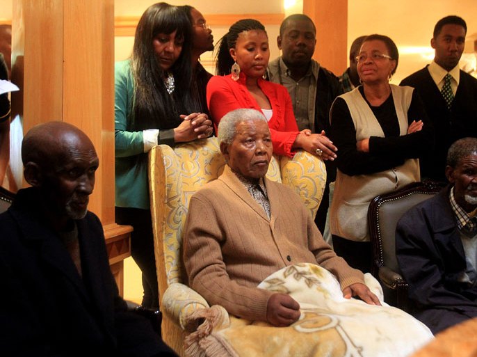 SOUTH AFRICA : In this handout picture received from the Nelson Mandela Foundation, Nelson Mandela (Foreground-C) and his wife Graca Machel (Background 2-R) look on during a ceremony at which he received a symbolic flame to mark the ruling ANC party's centenary at his home in Qunu on May 30, 2012.