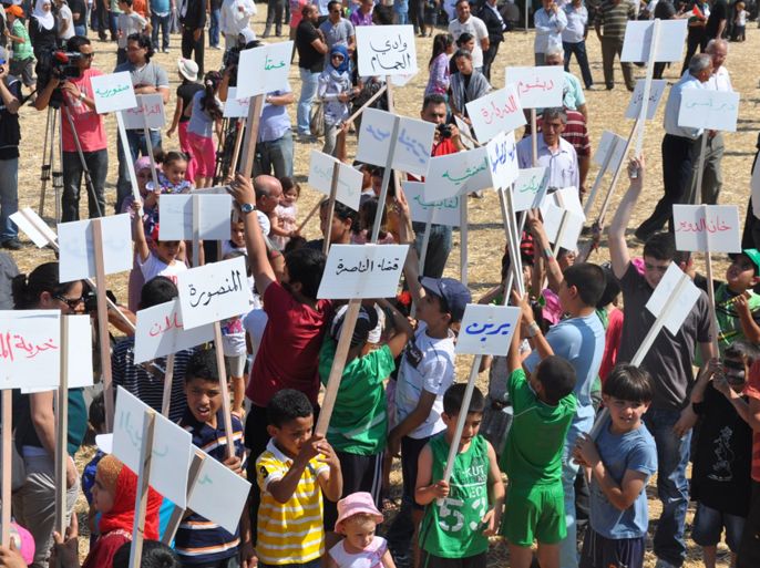 أطفال يحملون لافتات كتب عليها أسماء القرى الفلسطينية المهجرة