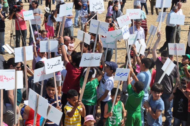 أطفال يحملون لافتات كتب عليها أسماء القرى الفلسطينية المهجرة