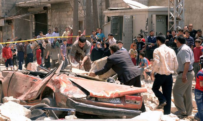epa03206978 A handout photo made available by Syrian Arab News Agency (SANA), shows the wreck of a car at the explosion site in al-Sukkari neighborhood in the northern province of Aleppo, Syria, 05 May 2012. According to SANA, three citizens, including a child, were killed and 21 other were injured in a booby-trapped car blast that went off on 05 May 2012 in front of a car wash.