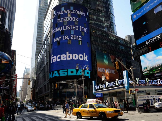 Pedestrians walk near the NASDAQ Marketsite at the start of the listing for Facebook in New York May 18, 2012. Facebook Inc. began trading on the Nasdaq with it's initial public offering at $38 per share, valuing the world's largest social network at more than $100 billion. REUTERS