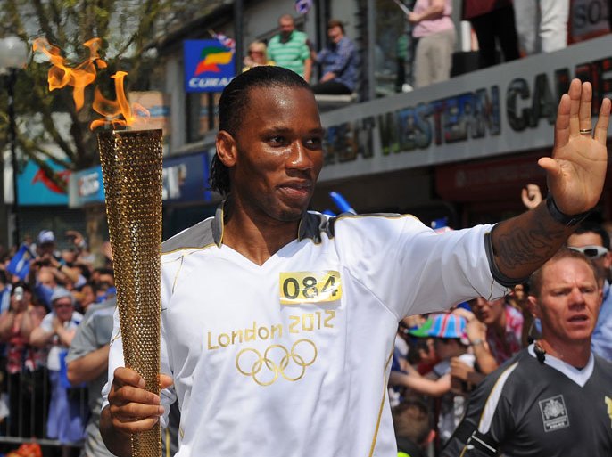 Former Chelsea footballer Didier Drogba runs with the 2012 London Olympic torch in the streets of Swindon, west of London, on May 23, 2012. Ivory Coast striker Didier Drogba confirmed on Tuesday he will leave newly-crowned European champions Chelsea when his contract expires at the end of June. AFP PHOTO/LOCOG