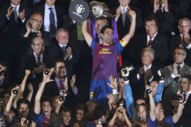 Barcelona's Xavi Hernandez lifts up the Spanish King's Cup trophy after winning their final soccer match against Athletic Bilbao at the Vicente Calderon stadium in Madrid, May 25, 2012. REUTERS/Felix Ordonez (SPAIN - Tags: SPORT SOCCER)