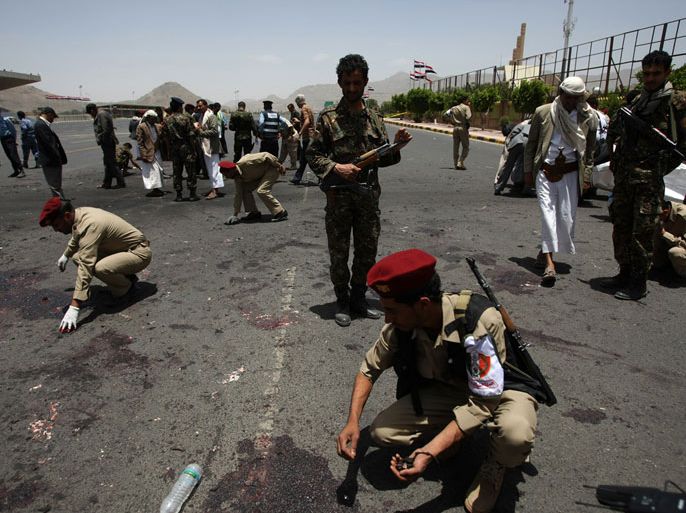 Yemeni military police collect evidence at the site of a suicide bomb attack in Sanaa on May 21, 2012. A Yemeni soldier packing powerful explosives under his uniform blew himself up in the middle of an army battalion the Yemeni capital, killing 96 troops and wounding around 300, a military official and medics said.