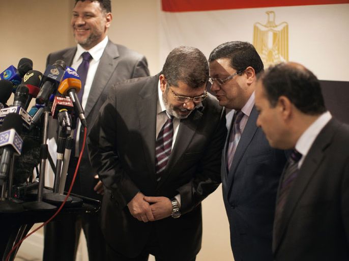 Muslim Brotherhood Egyptian presidential candidate Mohammed Mursi (2nd L) talks with an aid during a press conference in Cairo on May 26, 2012. The Muslim Brotherhood today urged Egyptians to rally behind their presidential candidate in an almost certain run-off with rival Ahmed Shafiq, warning the country would be in danger if fallen dictator Hosni Mubarak's premier wins