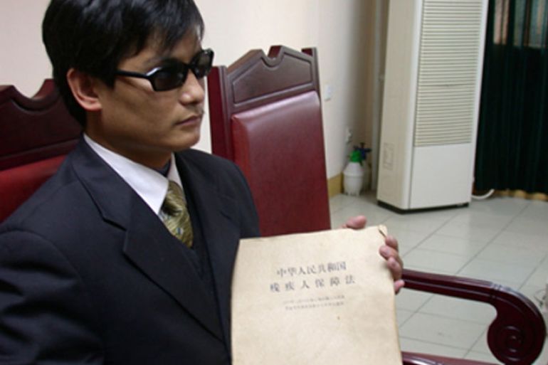 Blind legal activist Chen Guangcheng holds a document that reads: "Law of the People's Republic of China on the Protection of Disabled Persons", in this undated handout. U.S. Secretary of State Hillary Clinton arrived in China on Wednesday for top-level talks that risk being upstaged by the fate of Chen,