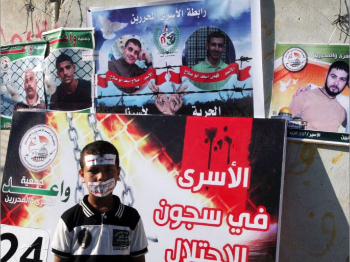 13- طفل يضع على فمه شعار اضراب الأسرى "جوعى للحرية"