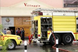 epa03239943 Firefighters vehicles at the entrance of the Villagio Mall as they try to extinguish a fire, in Doha, Qatar, 28 May 2012. At least 19 people, among them 13 children, died when a fire broke out on 28 May at a shopping mall in the Qatari capital Doha, the Ministry of Interior said. Four teachers and two civil defence workers were among those killed. EPA/STR