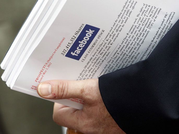 An investor holds a prospectus explaining the Facebook stock after attending a show for Facebook Inc's initial public offering at the Four Season's Hotel in Boston, Massachusetts in this file photo