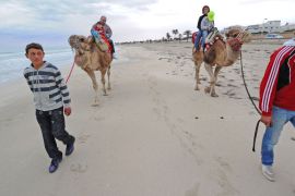 epa02635399 Tourists ride on camels on the beach of Ogla near Zarzis, Tunisia, 15 March 2011. EPA/CIRO FUSCO
