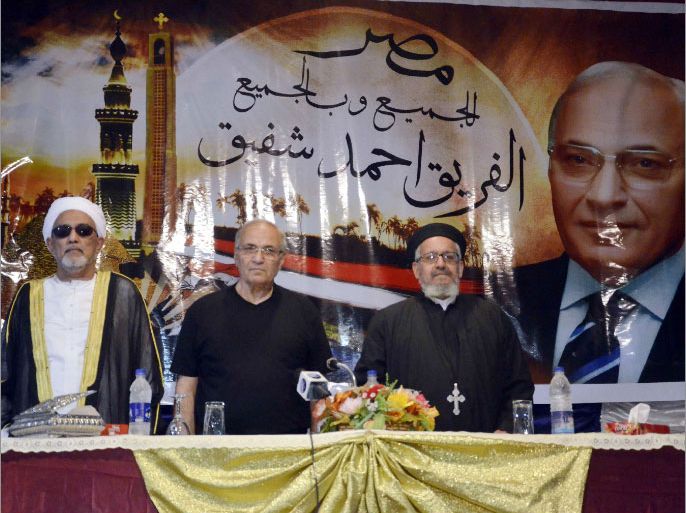Former prime minister and presidential candidate Ahmed Shafiq (C), Coptic priest Loqa Helal (R) and Islamic cleric Fathi al-Halawani (L) attend a campaign in Qena, some 650 km south of Cairo, on May 18, 2012. Shafiq's campaign shifted to a higher gear in recent weeks, with huge portraits of him in a suit, taking up the top spots of many buildings in Cairo and across the country. AFP PHOTO/STR