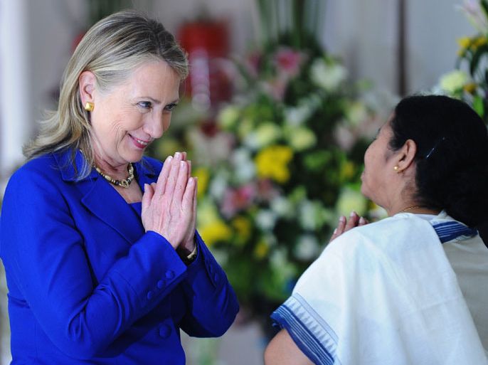 Kolkata, -, INDIA : US Secretary of State Hillary Clinton (L) returns a traditional gesture from India's West Bengal state Chief Minister Mamata Banerjee at the Writers' Building, which houses the state secretariat, in Kolkata on May 7, 2012. US Secretary of State Hillary Clinton said May 7 she hoped the United States would elect a woman as president during her lifetime, but again rejected calls for her to make a new White House run. Clinton said that women still suffered from a "glass ceiling" in politics, complaining that media write of the "pastel hues" in women leaders' wardrobes even when they are talking about defence policy. AFP PHOTO/Dibyangshu SARKAR