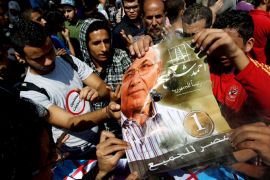 Egyptian protesters set a portrait of former premier and presidential candidate Ahmed Shafiq on fire during a demonstration outside the Supreme Consitutional Court in central Cairo on June, 14, 2102, after the court ruled that a law barring Shafiq and other senior Mubarak officials from standing for public office was unconstitutional. AFP